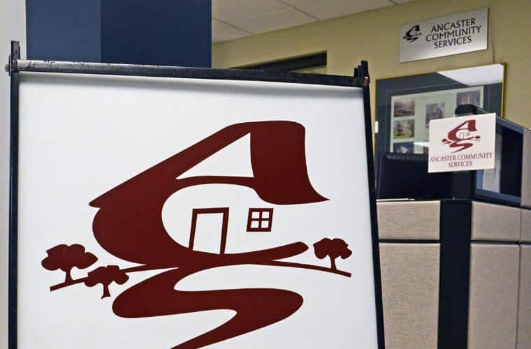 The sign for Ancaster Community Services inside an office.