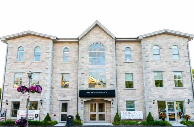 A large three story cream coloured rough hewn stone building.