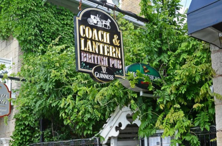 The sign for Coach & Lantern British Pub hanging above its entrance.
