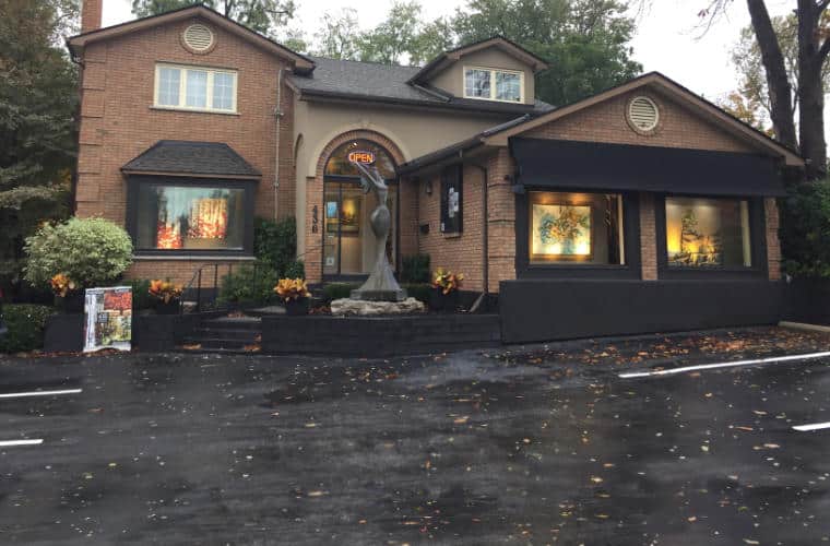 A large red brick house with artwork in the windows.