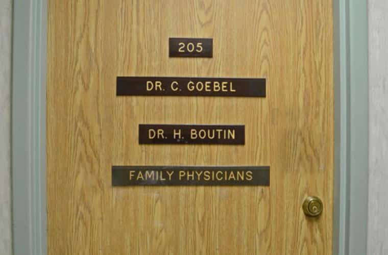 A wood door with a Plaque for Dr. C. Goebel and Dr. H. Boutin Family Physicians on it.