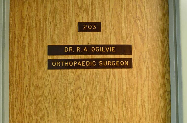 A wooden door with a plaque for Dr. R. A. Ogilvie Orthopaedic Surgeon on it.