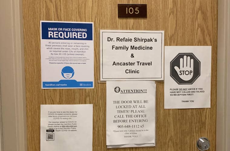 A wooden door with a sign for Dr. Refaie Shirpak's Family Medicine & Ancaster Travel Clinic on it.