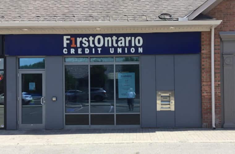 A blue storefront with a sign for FirstOntario Credit Union above a large window.