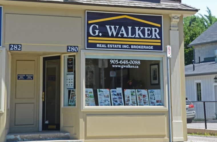 A beige storefront with a sign for G. Walker Real Estate above the front window.