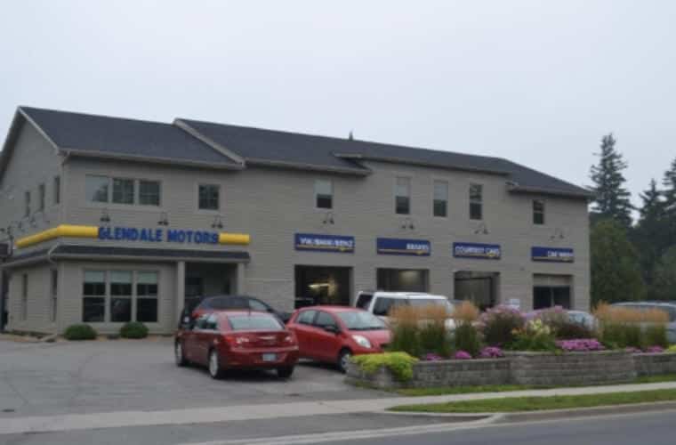 A large grey building with multiple garages and a sign for Gleddale Motors.