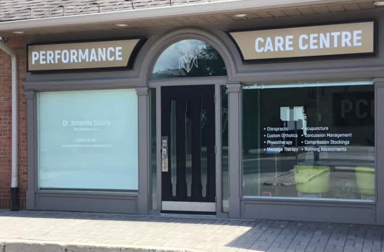 A window wall storefront with a sign for Performance Care Centre above the entrance.