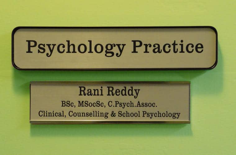 A green wall with a sign for Psychological Practitioner Rani Reddy on it.