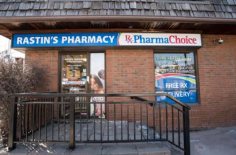 A red brick building with a sign for Rastin's Pharamy above the entrance.