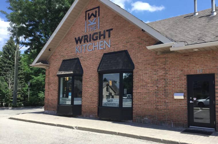 A large red brick building with peaked roof and a sign for The Wright Kitchen above the front windows.