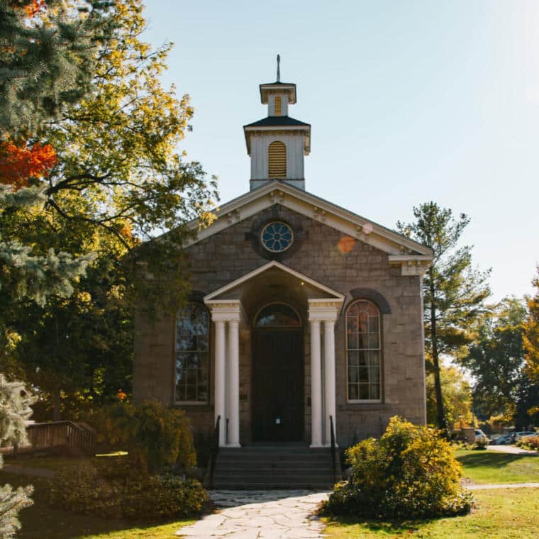A small stone building with pillared front porch.